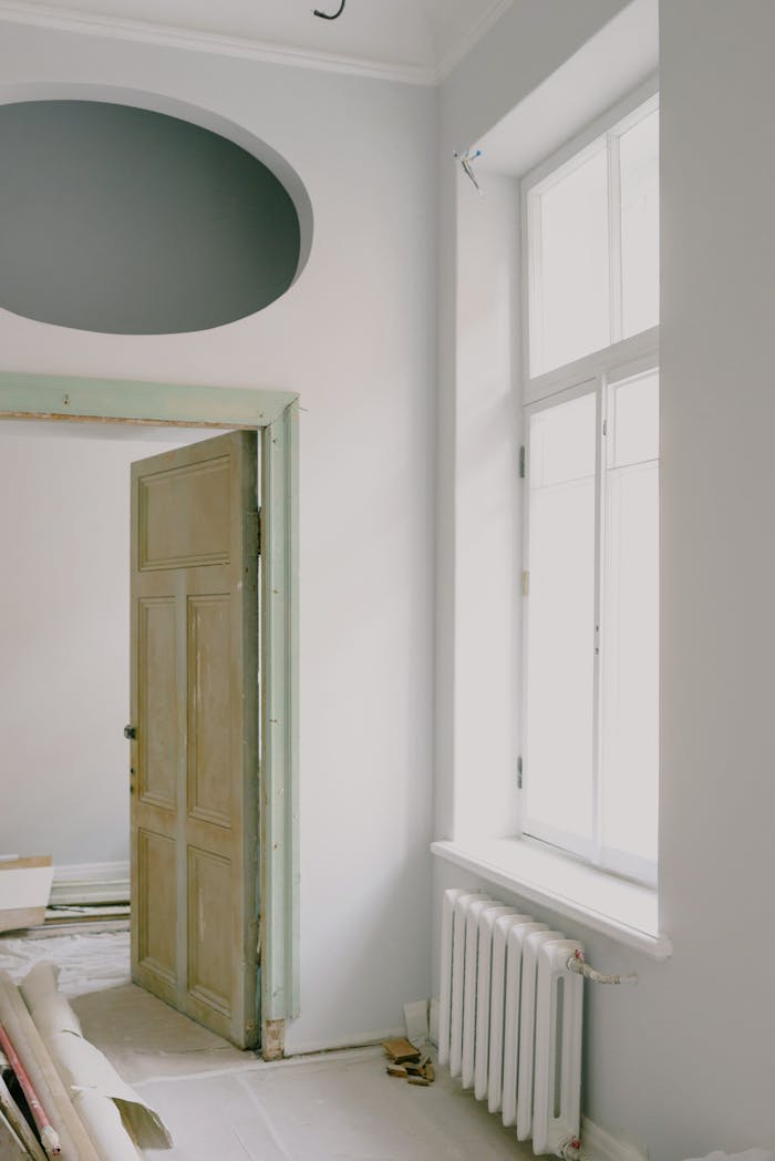 our-value Contemporary apartment interior with shiny window and door near construction materials on floor in daytime