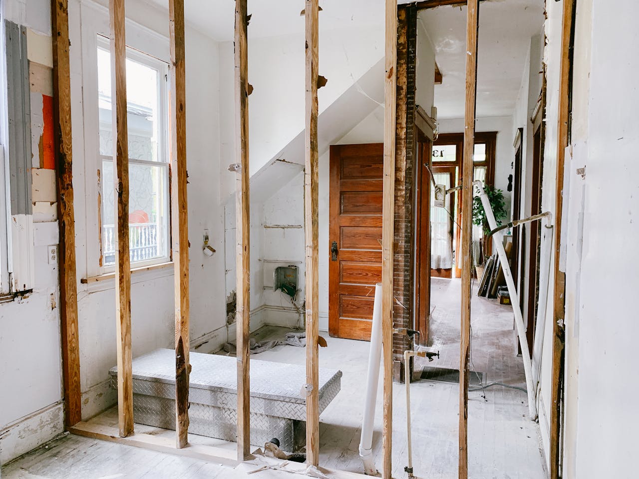 about-img-02 Interior view of a home under renovation with exposed wooden beams and door.